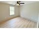 Bedroom featuring a ceiling fan, wood floors, neutral paint, and large window at 299 Lagrange St, Grantville, GA 30220