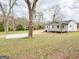 Well-maintained lawn and mature trees surrounding a quaint, single-story home at 299 Lagrange St, Grantville, GA 30220