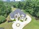 Expansive property features a manicured lawn, lush landscaping, and a grand home with a circular driveway at 4233 Sandstone Shores Dr, Stonecrest, GA 30038