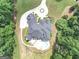 Aerial view of a home surrounded by greenery, featuring circular driveway and a backyard pool at 4233 Sandstone Shores Dr, Stonecrest, GA 30038