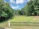 Expansive backyard with a tranquil pond, surrounded by lush trees at 4233 Sandstone Shores Dr, Stonecrest, GA 30038