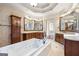 A luxury bathroom features a soaking tub, marble countertops, and wood cabinets for storage at 4233 Sandstone Shores Dr, Stonecrest, GA 30038