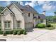 Side view of a brick home with an attached garage and beautiful landscaping at 4233 Sandstone Shores Dr, Stonecrest, GA 30038