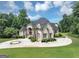 Beautiful home featuring a circular driveway, mature trees, and manicured shrubs at 4233 Sandstone Shores Dr, Stonecrest, GA 30038