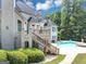 Back of the house with staircase leading to an in-ground pool at 4233 Sandstone Shores Dr, Stonecrest, GA 30038