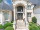 Elegant front entrance with decorative iron doors and manicured landscaping at 4233 Sandstone Shores Dr, Stonecrest, GA 30038