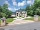 Beautiful two-story home with a circular driveway and manicured landscaping and entrance sign at 4233 Sandstone Shores Dr, Stonecrest, GA 30038