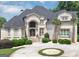 Elegant two-story home showcasing a meticulously landscaped front yard and circular driveway at 4233 Sandstone Shores Dr, Stonecrest, GA 30038