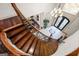 Elegant curved staircase with wrought iron railing and hardwood steps leading to a bright foyer at 4233 Sandstone Shores Dr, Stonecrest, GA 30038