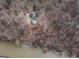 An aerial view features a large home with an overgrown yard and a dock along the river at 650 Malcom Rd, Covington, GA 30014