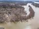 A high aerial view shows the lake house settled among trees with lake access on a large river at 650 Malcom Rd, Covington, GA 30014