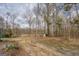 This shot displays the natural backyard with mature trees, a quaint storage shed, and water in the distance at 650 Malcom Rd, Covington, GA 30014