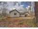 This view displays a charming home exterior with a wooden walkway, lush landscaping, and mature trees at 650 Malcom Rd, Covington, GA 30014