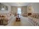 Spacious living room featuring plush striped sofas, a wooden coffee table, and bright natural lighting at 650 Malcom Rd, Covington, GA 30014