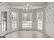 Charming dining area with a chandelier, tiled floor, three windows, and a door to the deck at 807 Ivy Ridge Dr, Loganville, GA 30052