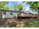 A large wooden deck accents the rear exterior of this home with a level yard and mature trees at 1620 Summit Rdg, Auburn, GA 30011