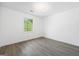 A cozy bedroom boasts white walls, wood-look flooring, and a bright window with natural light at 1620 Summit Rdg, Auburn, GA 30011