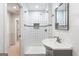 Modern bathroom featuring a tiled shower with mosaic accents, a stylish sink, and shiplap walls at 430 Gregory Rd, Covington, GA 30014