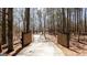 Private driveway entrance with wooden gates amidst a serene, wooded landscape at 430 Gregory Rd, Covington, GA 30014