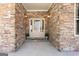Charming front entrance featuring a stone facade, glass panel door, and sconce lighting at 430 Gregory Rd, Covington, GA 30014