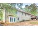 Home's back exterior with a walkout basement, a wooden deck with stairs, and a spacious backyard at 1300 Lakehaven Pkwy, Mcdonough, GA 30253