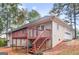 Home's back exterior with a wooden deck, stair access, and an attached two-car garage on a sloped lot at 1300 Lakehaven Pkwy, Mcdonough, GA 30253