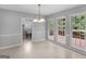 Open dining area with a chandelier, large windows, and a view into the washroom with utility sink at 1300 Lakehaven Pkwy, Mcdonough, GA 30253