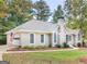 Charming home with manicured landscaping, a gray roof, a chimney, and a two-car garage on a spacious lot at 1300 Lakehaven Pkwy, Mcdonough, GA 30253