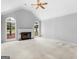 Spacious living room with vaulted ceilings, fireplace, neutral carpeting, and abundant natural light at 1300 Lakehaven Pkwy, Mcdonough, GA 30253