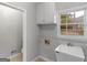 A clean washroom with a utility sink, cabinets, and a window, alongside convenient washer and dryer connections at 1300 Lakehaven Pkwy, Mcdonough, GA 30253