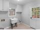 Cozy laundry room featuring a utility sink, white cabinets, window, and access to the back exterior at 1300 Lakehaven Pkwy, Mcdonough, GA 30253