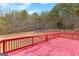 A spacious red wooden deck overlooks a large, fenced backyard with mature trees at 510 Virginia Highlands, Fayetteville, GA 30215