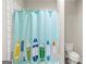 Bathroom showing a bathtub with surfboard patterned curtain and a standard toilet at 157 Waterlace Way, Fayetteville, GA 30215