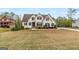 A stunning two-story white brick home featuring dark shutters, well-manicured landscaping, and a luscious lawn at 157 Waterlace Way, Fayetteville, GA 30215