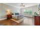 A well lit main bedroom features hardwood floors, stylish wallpaper and a luxurious bed at 157 Waterlace Way, Fayetteville, GA 30215