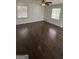 Spacious bedroom featuring hardwood floors, a ceiling fan, and natural light at 220 Cabriolet Trl, Mcdonough, GA 30253