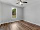 Bright bedroom features a ceiling fan, wood-look floors and a view to the yard at 4139 Alayna Lee Cir, Mcdonough, GA 30252