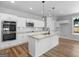 Modern kitchen featuring white cabinets, stainless steel appliances, a large island and a window at 4139 Alayna Lee Cir, Mcdonough, GA 30252