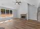 Bright living room featuring wood floors, vaulted ceilings, a stone fireplace, and large windows at 4139 Alayna Lee Cir, Mcdonough, GA 30252