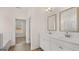 Bright bathroom featuring double sink vanity with modern fixtures, a framed mirror, and wood-look flooring at 1712 Goodwin Dr, Hampton, GA 30228