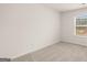 Neutral-toned bedroom features natural light from a window overlooking the backyard at 1712 Goodwin Dr, Hampton, GA 30228