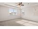 Bright bedroom featuring neutral carpet, ceiling fan, and windows allowing natural light to flow throughout at 1712 Goodwin Dr, Hampton, GA 30228