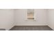 An empty walk in closet with neutral carpet, a window, and wire shelving installed at 1712 Goodwin Dr, Hampton, GA 30228
