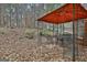 Backyard patio area featuring an orange gazebo, seating, and view of the wooded lot at 165 Standing Oak Pl, Fayetteville, GA 30214