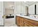 Bathroom featuring double vanity with wood cabinets, a large mirror, and bright lighting at 165 Standing Oak Pl, Fayetteville, GA 30214