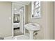 Pedestal sink bathroom with white tile flooring, an open doorway, and a window at 165 Standing Oak Pl, Fayetteville, GA 30214