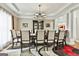 Elegant dining room with a large table, chandelier, and decorative trim at 165 Standing Oak Pl, Fayetteville, GA 30214