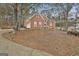 Well-maintained red brick home with a multi-car garage, featuring lush landscaping and a serene wooded backdrop at 165 Standing Oak Pl, Fayetteville, GA 30214