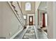 Inviting home foyer featuring tiled floors, an elegant staircase, and a decorative front door at 165 Standing Oak Pl, Fayetteville, GA 30214