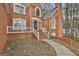 Close-up of brick house with white trim featuring a stately front entrance and decorative windows at 165 Standing Oak Pl, Fayetteville, GA 30214